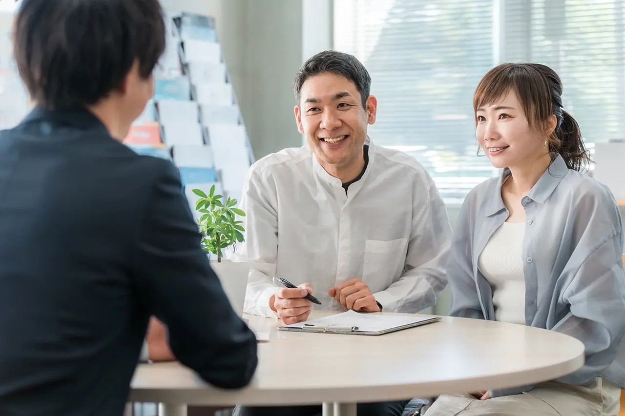 店舗で自動車保険の相談をする笑顔の夫婦